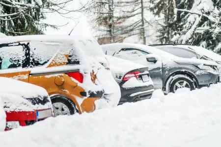 Several parked cars covered in snow