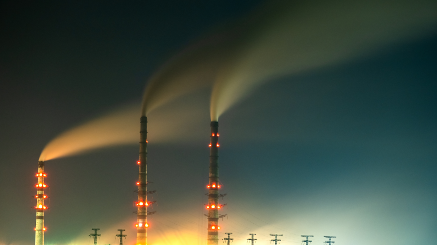 Smokestacks emitting pollution into the night sky