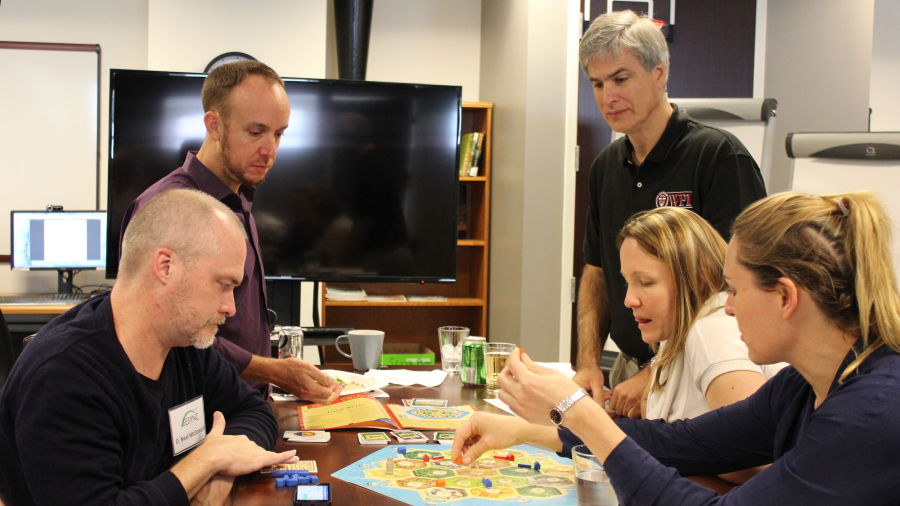 Five people around a table engaging in a game