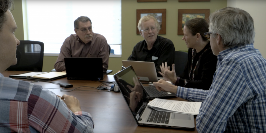 Members of the research team seated around a table having a discussion