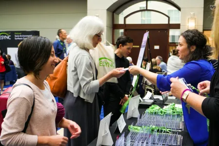 Attendees approaching the welcome table at the symposium