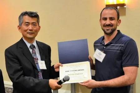 A photo of Nick Magliocca being presented with an award