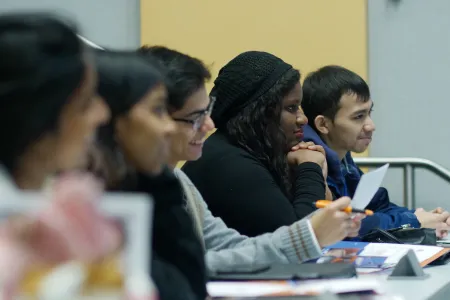 A group of students sitting in a row in a classroom 