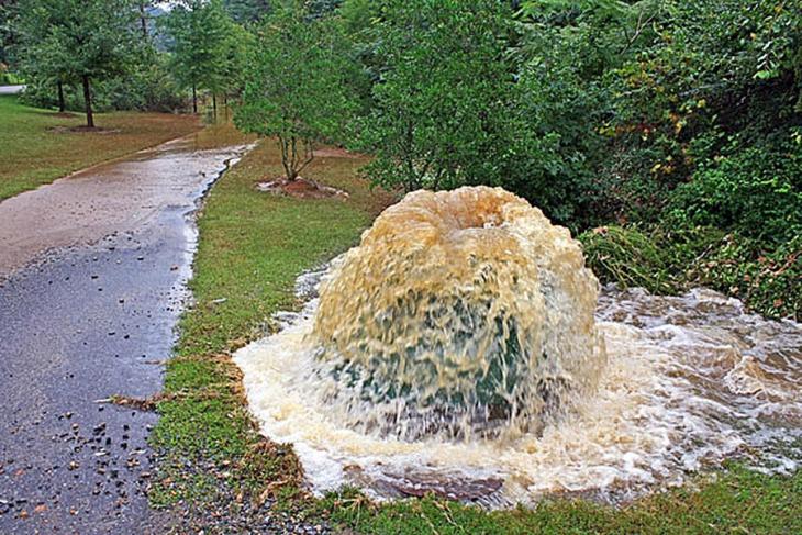 An example of combined sewer overflow, which appears to be like a geyser of water next to a sidewalk