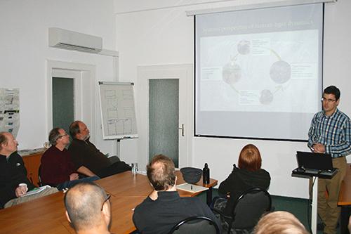 Neil Carter standing in front of a small group of people presenting research on a screen